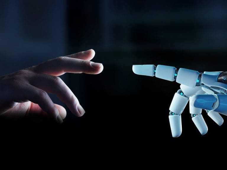 Eine menschliche Hand und eine mechanische nähern sich mit den Fingern an.