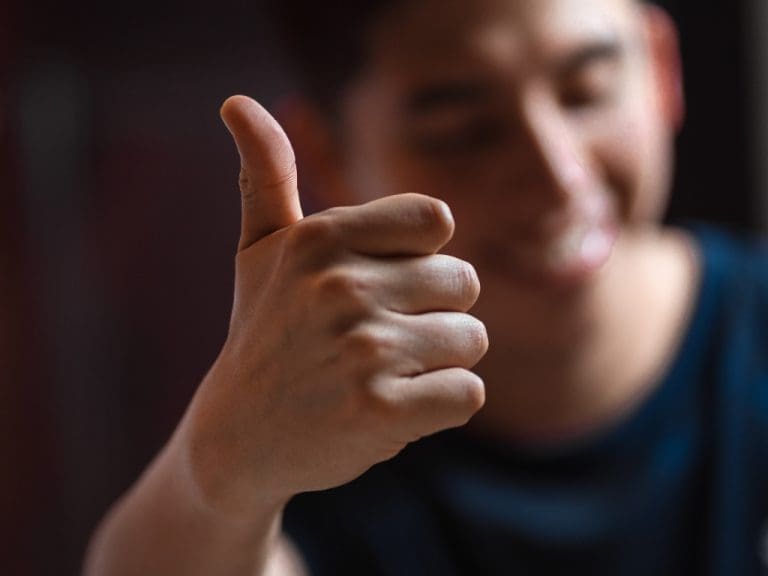 Mann zeigt Daumen hoch als Zeichen der Zufriedenheit