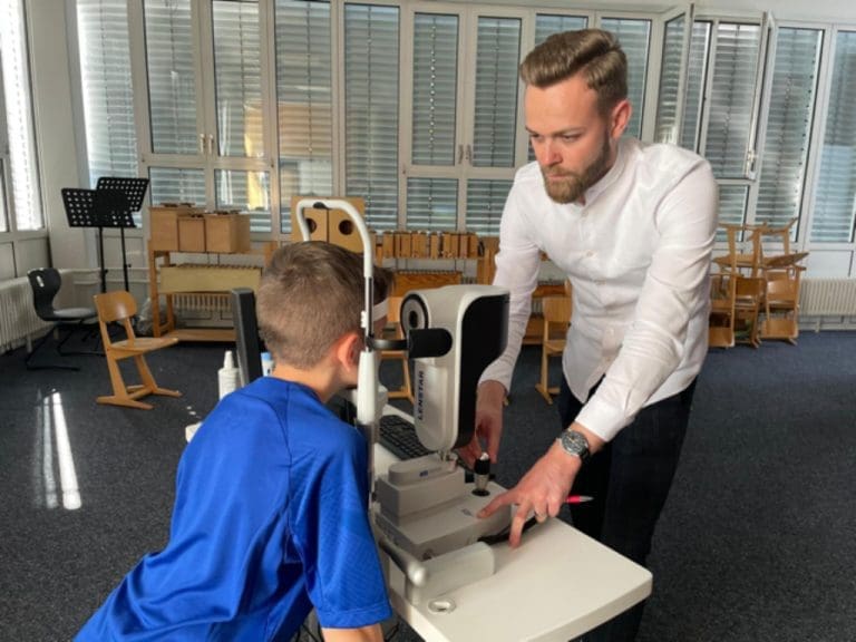 Manuel Stanke von Visionix bei der Augenuntersuchung eines Schülers mit dem Biometer