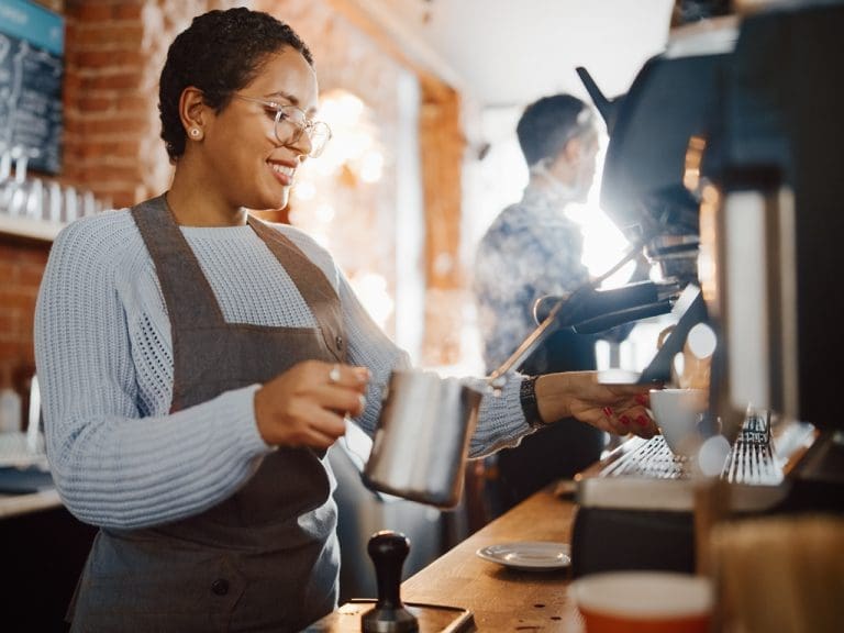 Weiblicher Barista trägt Raumgleitsichtgläser „Nah + Raum“ von Rupp + Hubrach