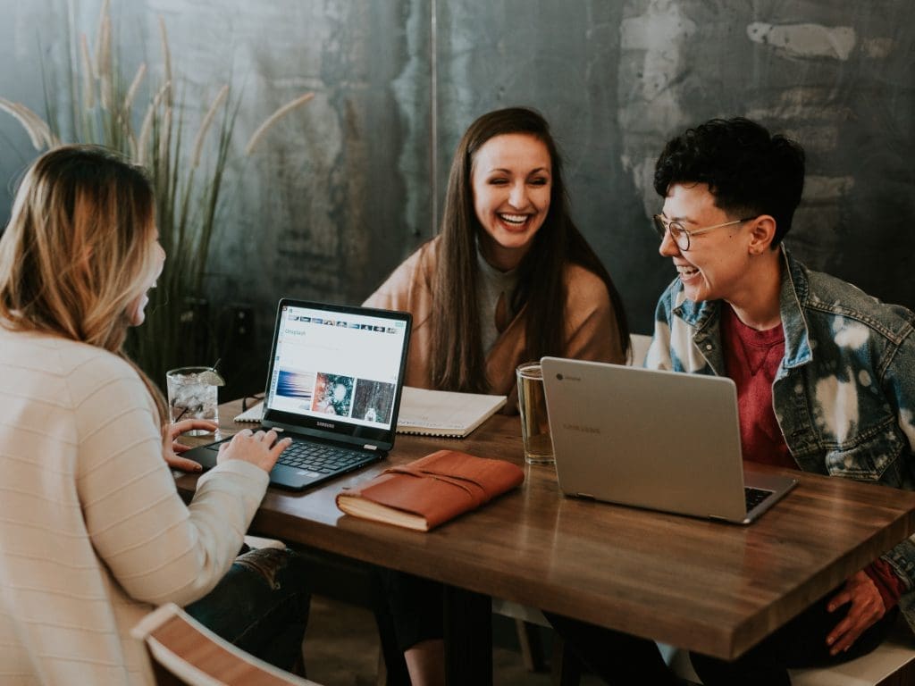 Junge Menschen mit Freude bei der Arbeit am Laptop