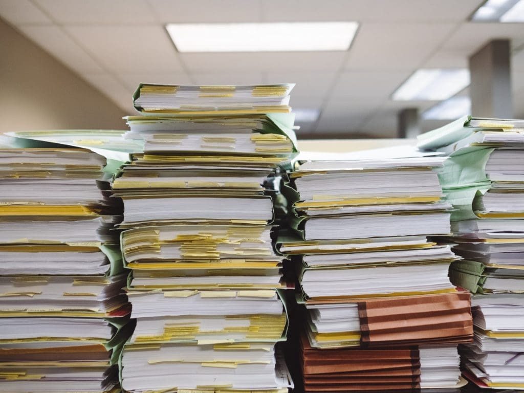 Aktenordner stapeln sich auf einem Tisch