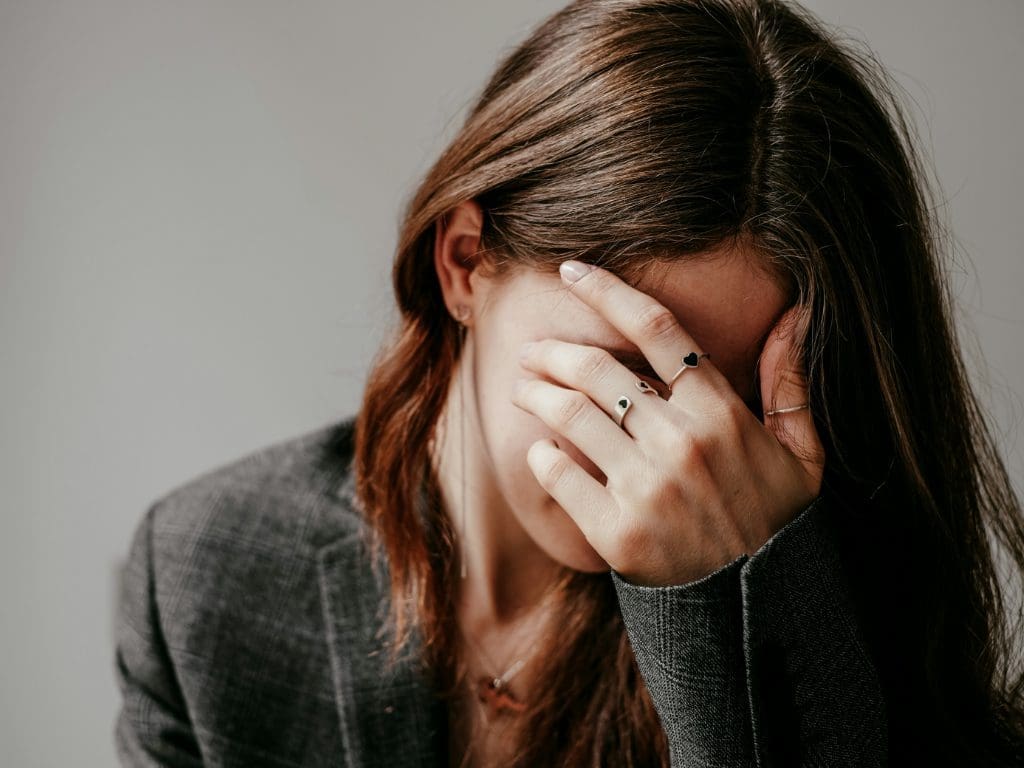 Frau hält sich Hände vor das Gesicht