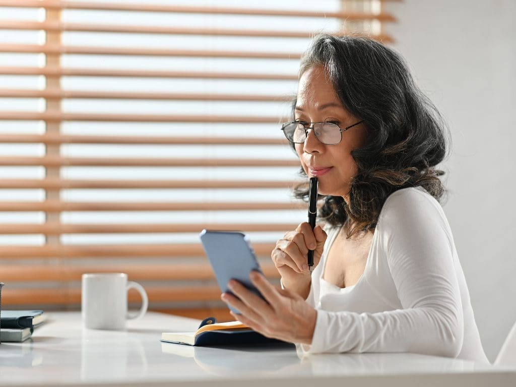 Presbyope (altersweitsichtige) Frau schaut auf Smartphone
