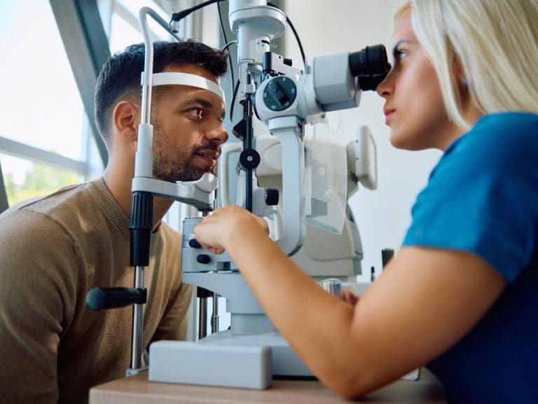 Junger Mann lässt seine Augen von Augenärztin untersuchen