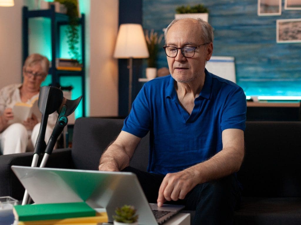 Älterer Mann benutzt Laptop auf Tisch für Augenkontrolle