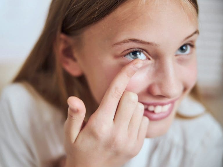 Mädchen setzt Kontaktlinse ein