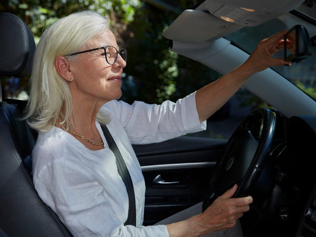 Ältere Verkehrsteilnehmerin hinter Steuer im PKW