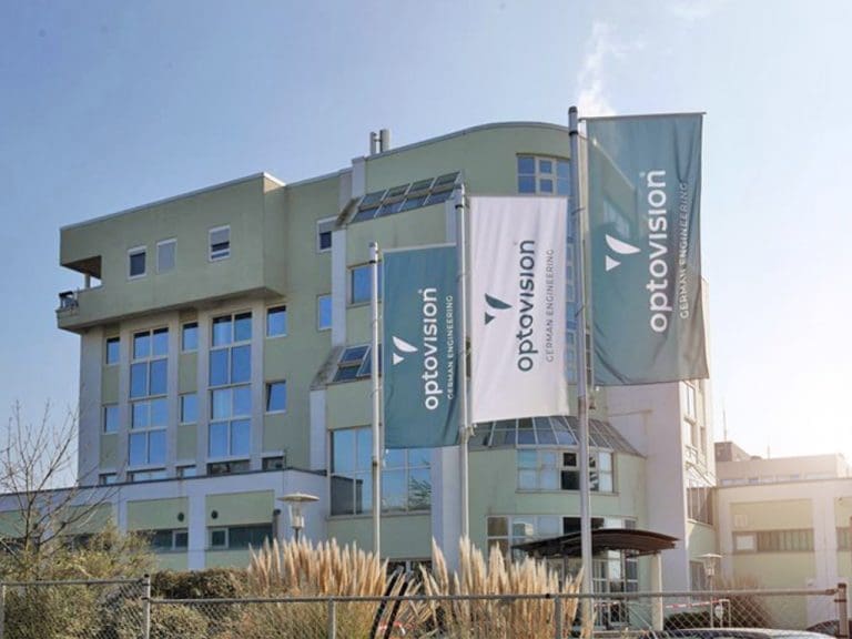 Optovision-Werk in Langen (Hessen) von außen mit wehenden Fahnen