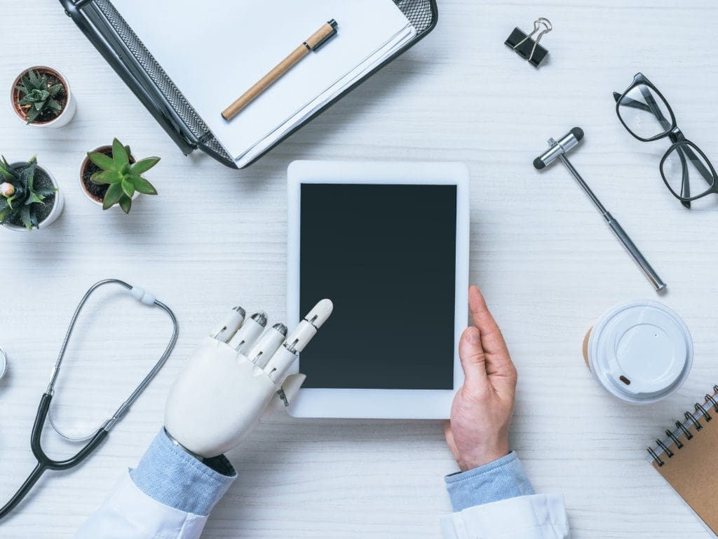 KI-gesteuerte Hand und menschliche Arzthand bedienen gemeinsam ein Tablet