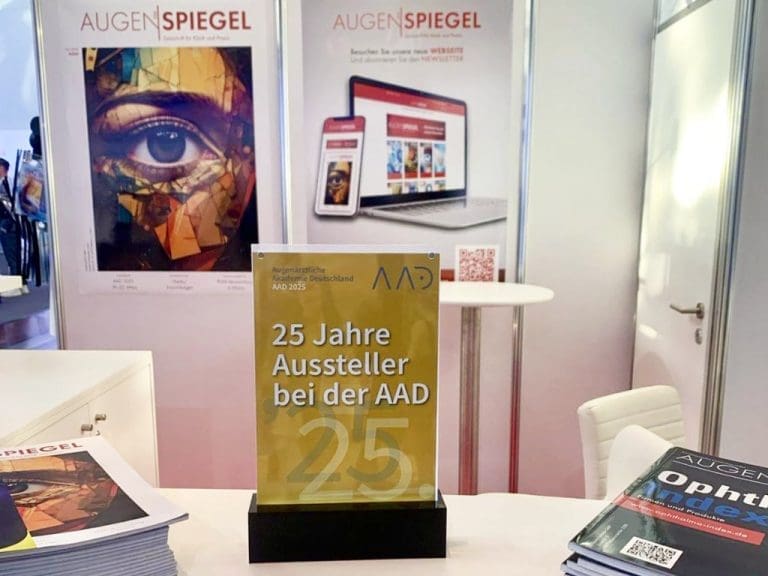 Ausstellerstand der Fachzeitschrift DER AUGENSPIEGEL, das einen Aufsteller mit der Aufschrift 25 Jahre Aussteller bei der AAD zeigt