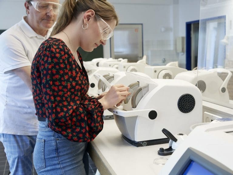 Junge Frau bei Brillenschliff, Reparatur und Anpassung – nur ein paar Dinge, die Augenoptiker-Auszubildende innerhalb von drei Jahren lernen