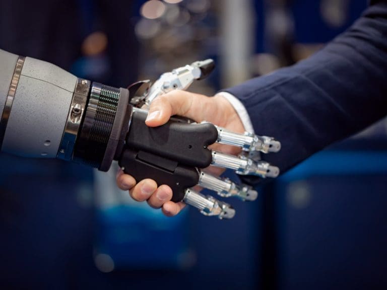 Hand eines Geschäftsmannes schüttelt Hand eines Android-Roboters