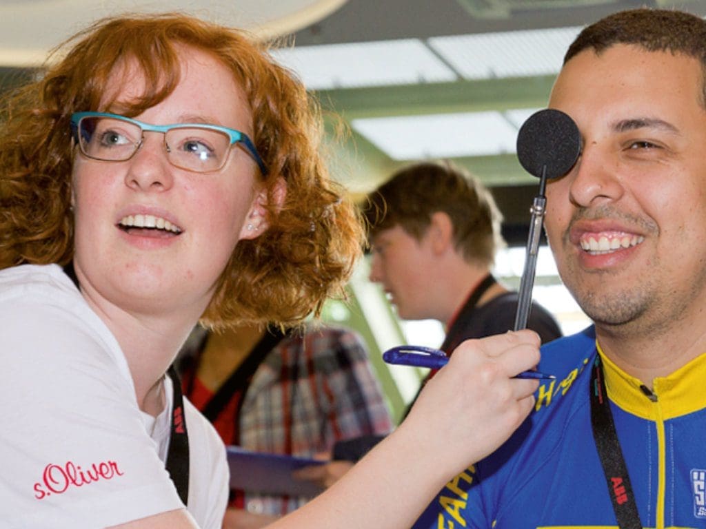 Augenoptikerin/Optometristin beim Sehtest eines männlichen Special Olympics-Athleten