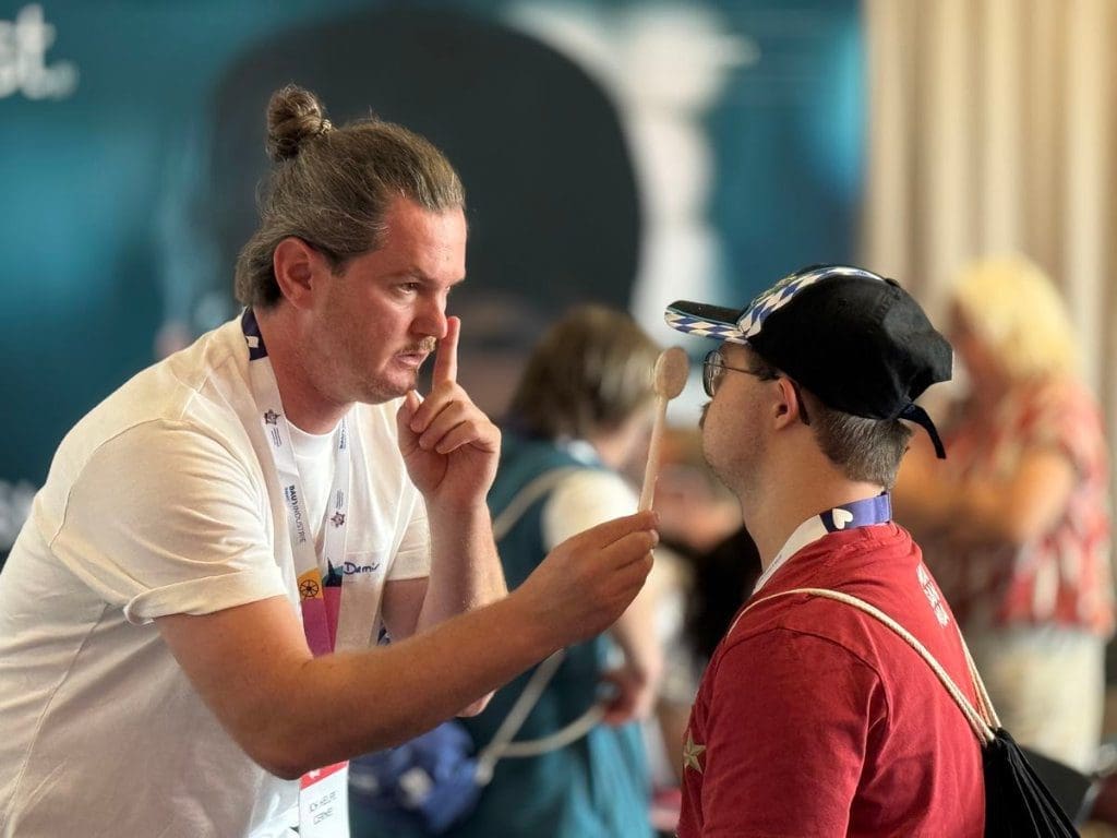 Männlicher Mitarbeiter der OneSight EssilorLuxottica Foundation macht Sehtest bei einem Sportler auf den Special Olympics Landesspielen Bayern 2025