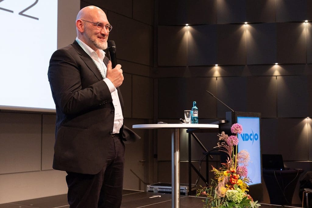 Stephan Hirschfeld steht mit einem Mikrofon auf der Bühne