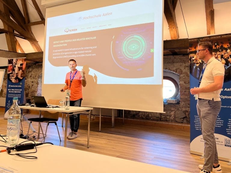 Dr. Matjaz Mihelcic, ECOO-Präsident past intermediate (links) und Tom Köllmer (rechts), beide Alumni und Modulverantwortliche für Clinical Experience, bei einem Vortrag auf dem 13. internationalen Weiterbildungskongresses für Augenoptik/Optometrie in Benediktbeuern