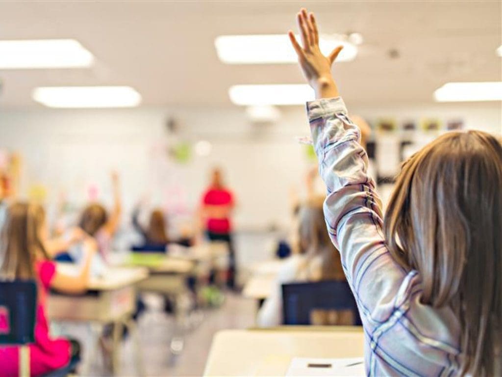 Schulkind im Klassenraum beim Aufzeigen