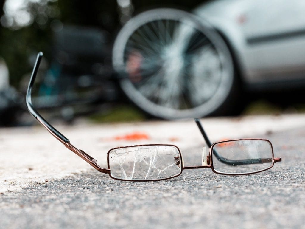 Kaputte Brille liegt vor Auto nach Unfall