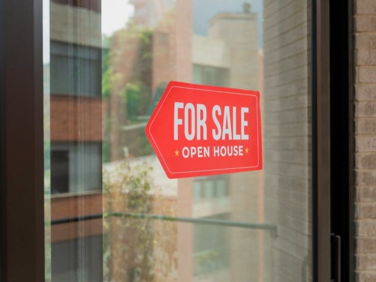 Fensterfront einer Gewerbeimmobilie mit Schild „For Sale“