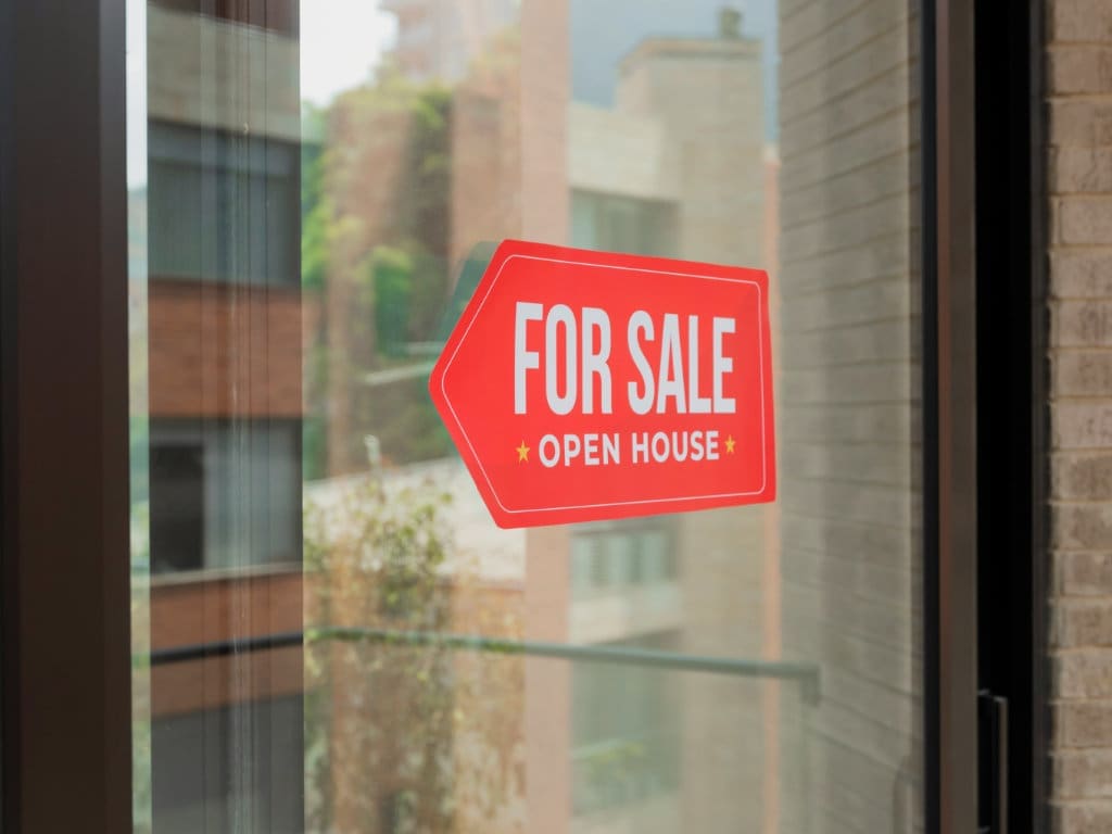 Fensterfront einer Gewerbeimmobilie mit Schild „For Sale“