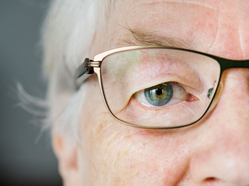 Nahansicht des Auges einer älteren Frau mit Brille
